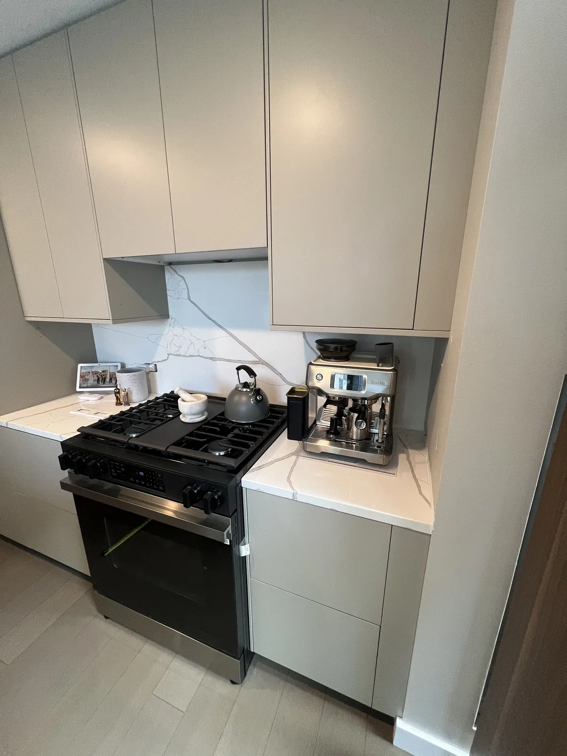 Completed IKEA kitchen installation with grey cabinets and professional gas range